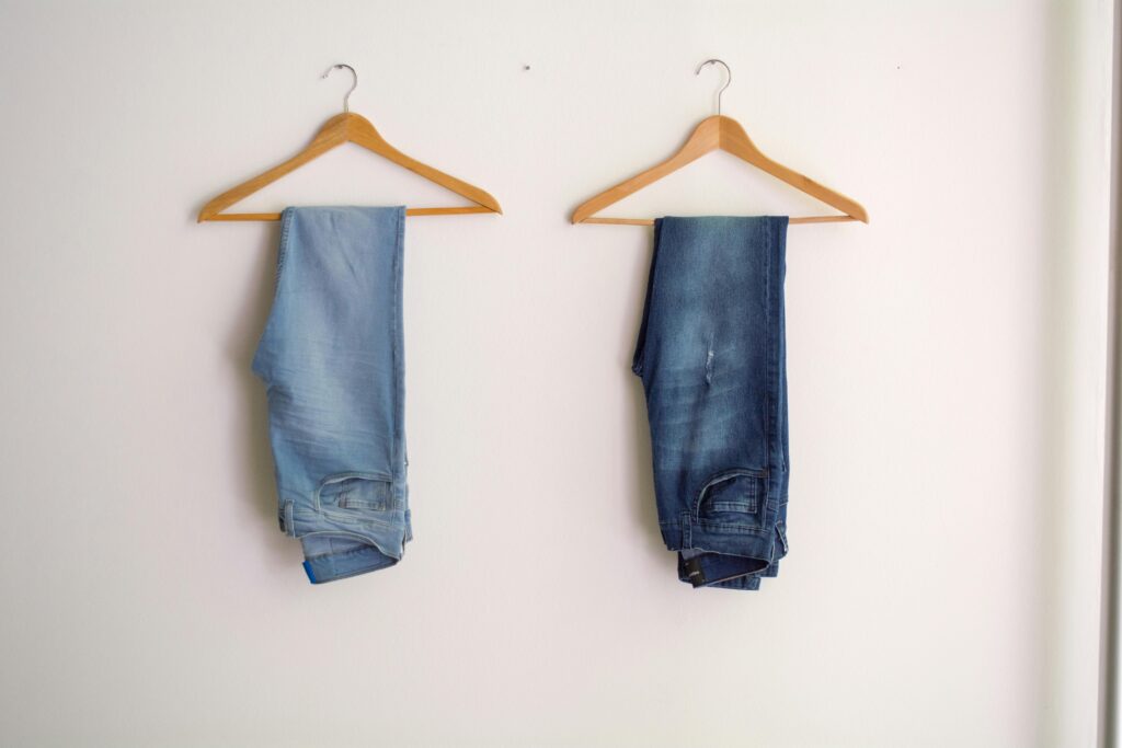 Deux paires de jeans accrochées sur le mur.