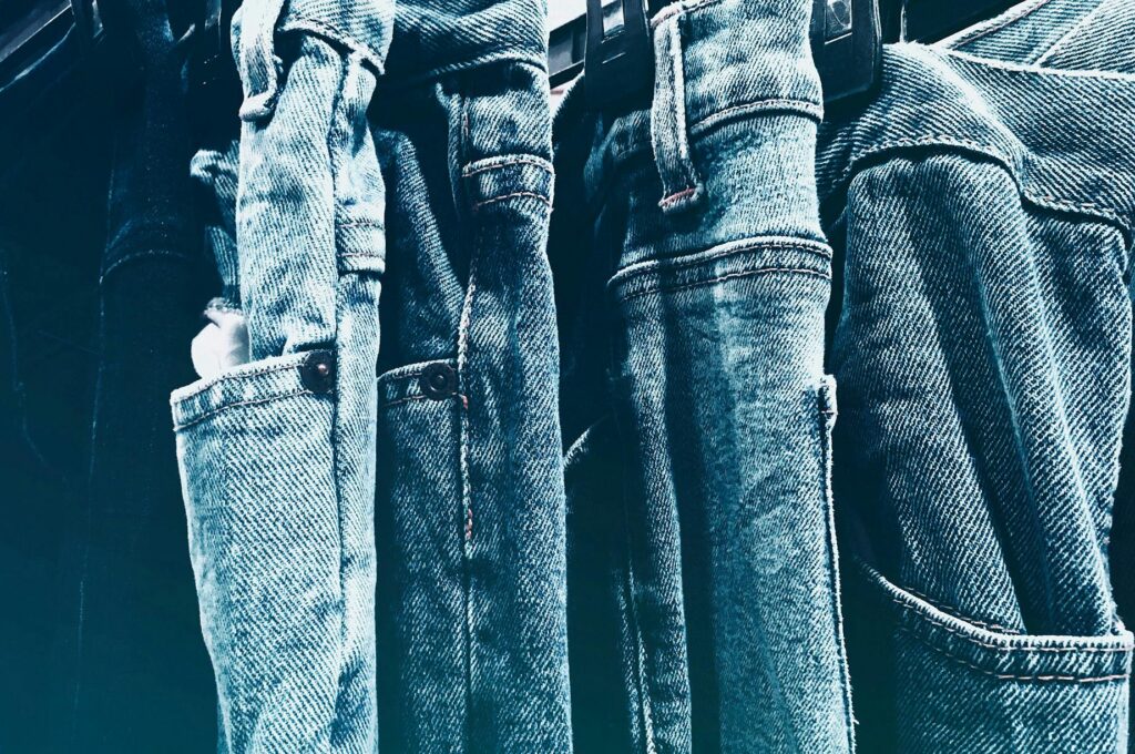 Cinq paires de jeans collées les unes sur les autres avec une teinte froide.